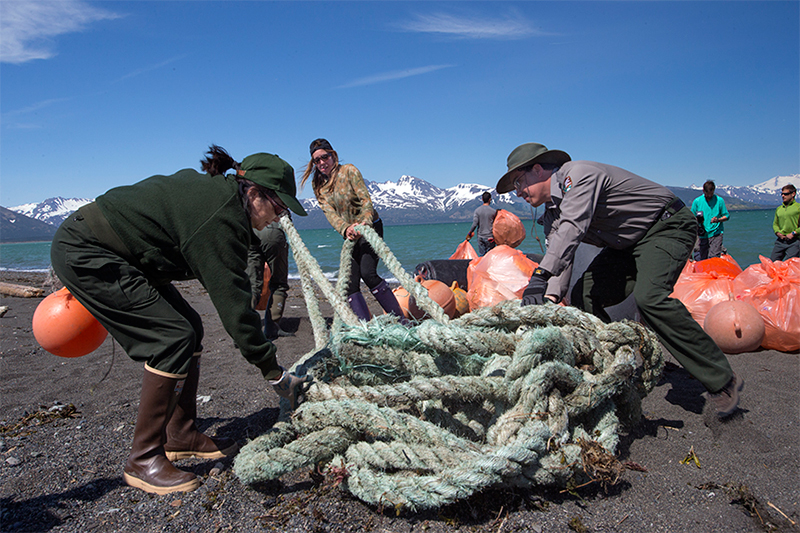 GYRE expedition participants drag trash off of Hallo Bay Beach. Much of the trash was gear from fishing boats. Photo © Kip Evans — GYRE)