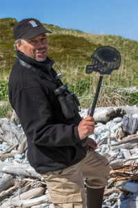 Author and marine biologist Carl Safina displays one of many football helmet-shaped fly swatters that were in the trash at Wonder Bay Beach. It was assumed that the items came from a shipping container. Photo © Kip Evans — GYRE